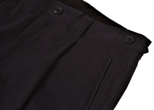 Load image into Gallery viewer, Close-up view of navy pants to demonstrate detailing of single pleat and expandable side button adjustment